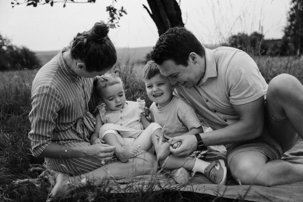 Familienfoto, sie kuschelt im Gras