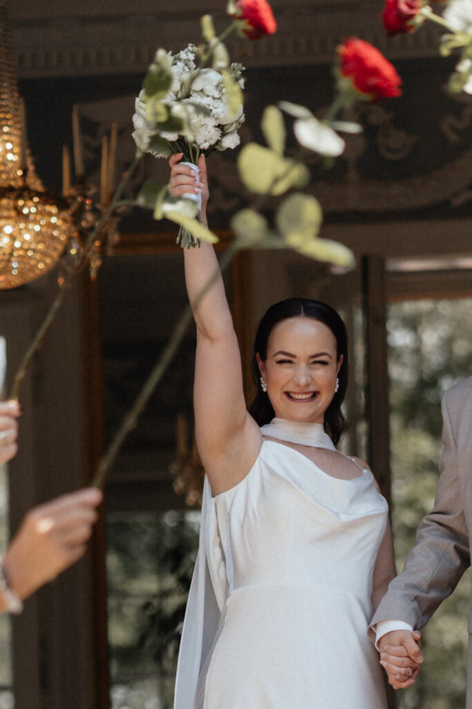 Braut jubelt mit Brautstrauß – Hochzeitsfotografin Aschaffenburg & Frankfurt